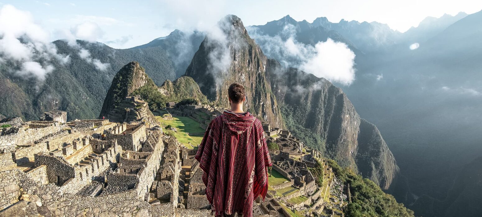 Machu Picchu con un turista con poncho típico