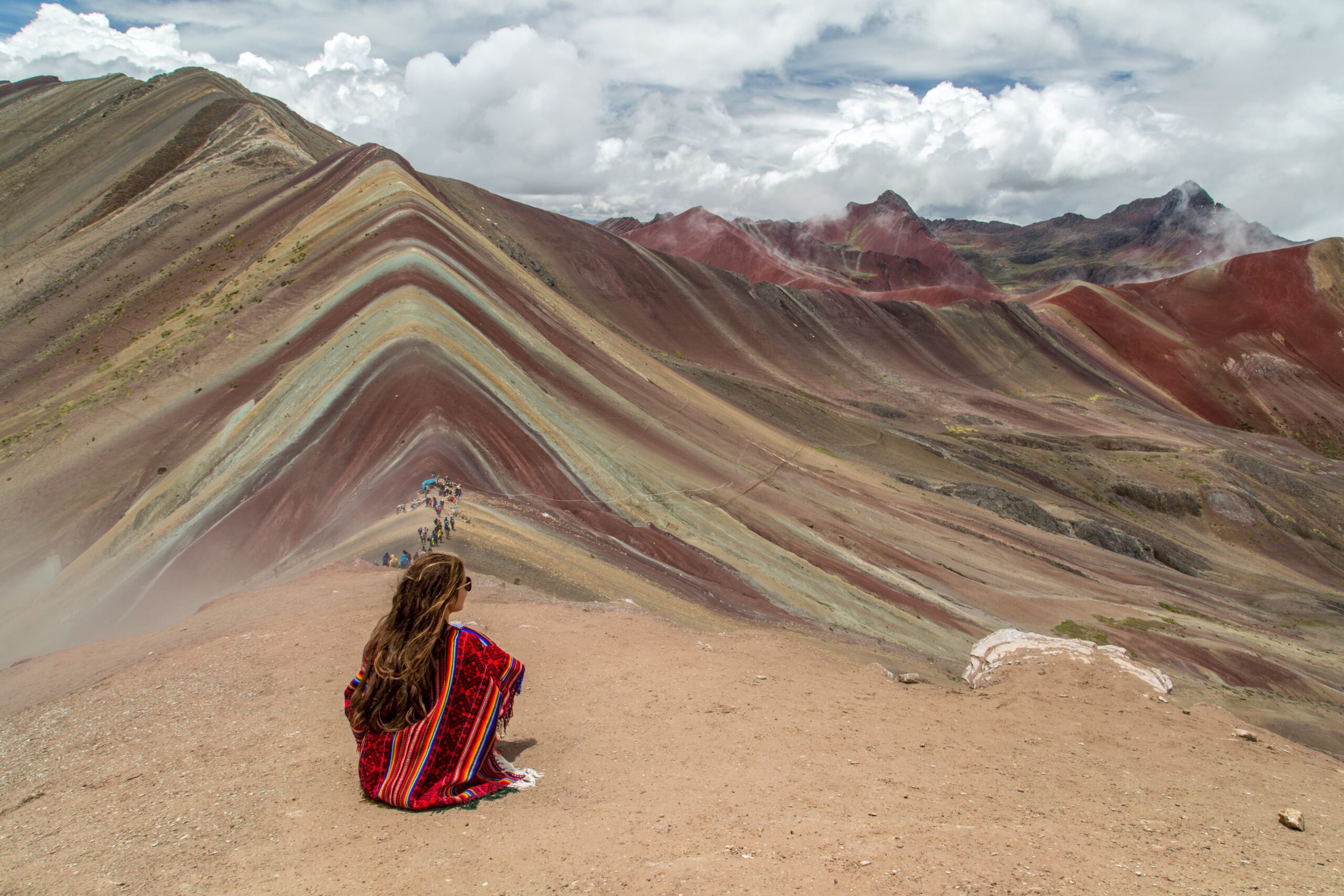 Una chica con Poncho en la monta de 7 colores Cusco