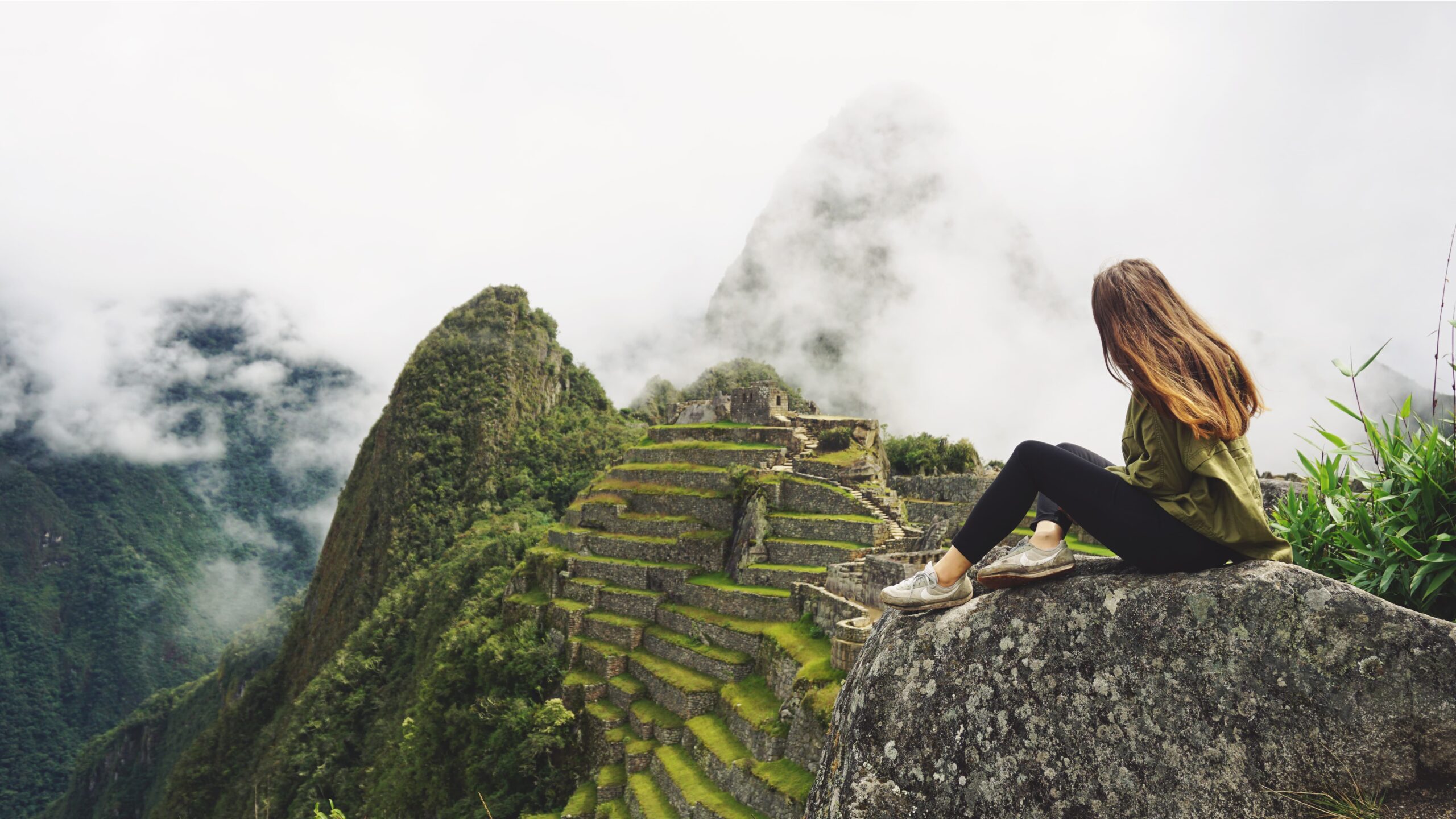 Una chica sentada en Machu Picchu